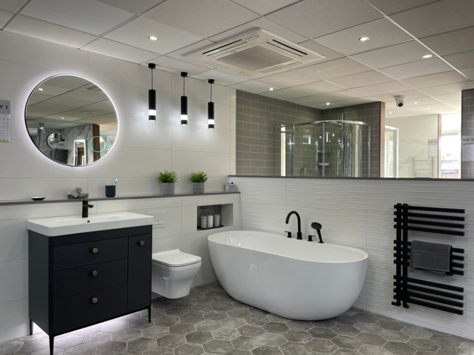 Freestanding bath, towel warmer, back-to-wall toilet, freestanding vanity unit, and a LED mirror in a stylish bathroom setting